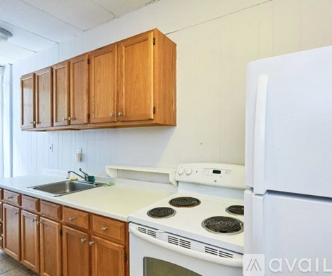 A kitchen with a white fridge, white stove and white countertop.