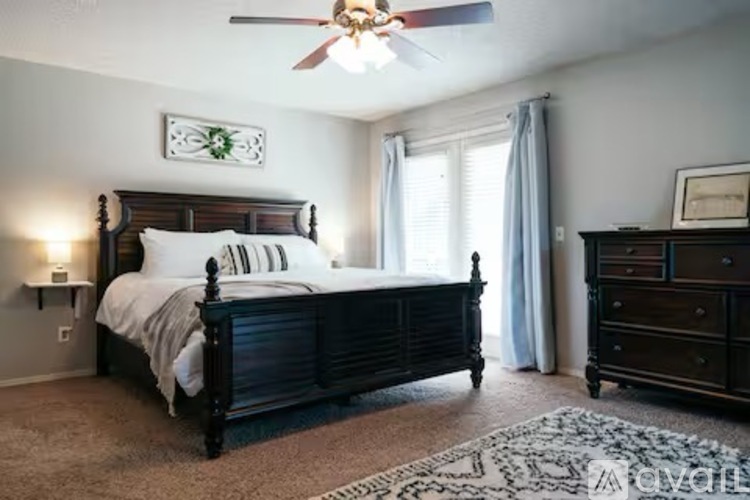 A bedroom with a large bed and a ceiling fan.