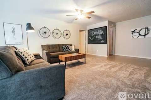 A living room with a grey couch and a wooden coffee table.