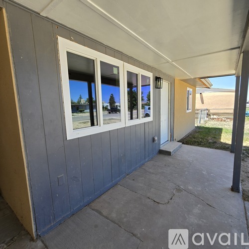 A house with a blue wall and a white door is available for rent.