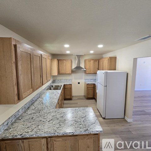 A kitchen with wooden cabinets and a marble countertop.