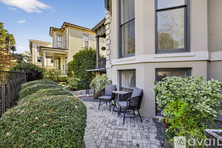 A patio with chairs and a table is in front of a building.