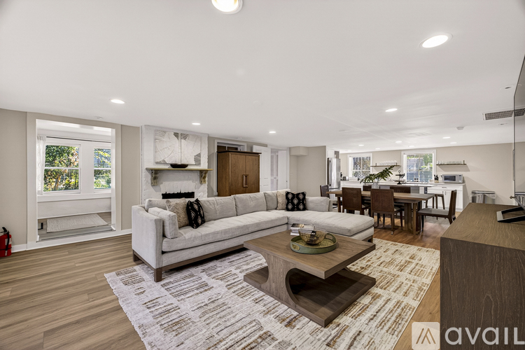 A modern living room with a white sofa and a coffee table in the center.