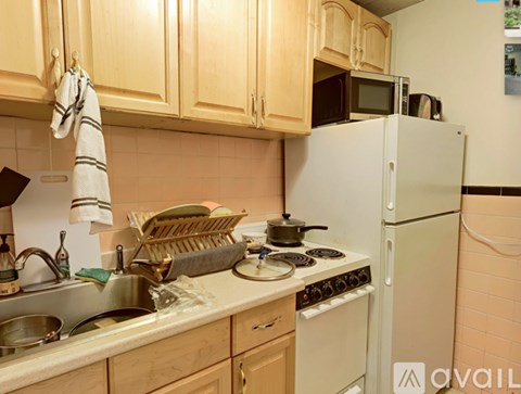 A kitchen with a white refrigerator, sink, and stove.