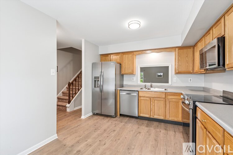 A kitchen with wooden cabinets and a refrigerator.