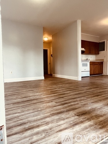 A living room with a kitchen in the background.