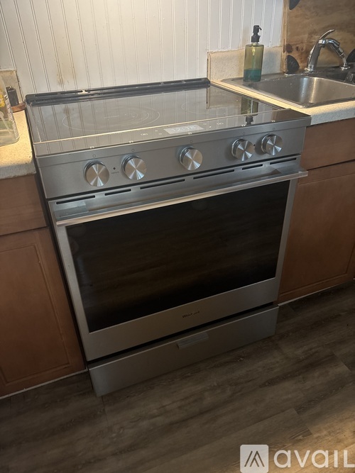A modern kitchen with a stainless steel oven and wooden cabinets.