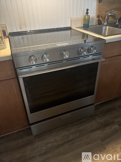 A modern kitchen with a stainless steel oven and wooden cabinets.
