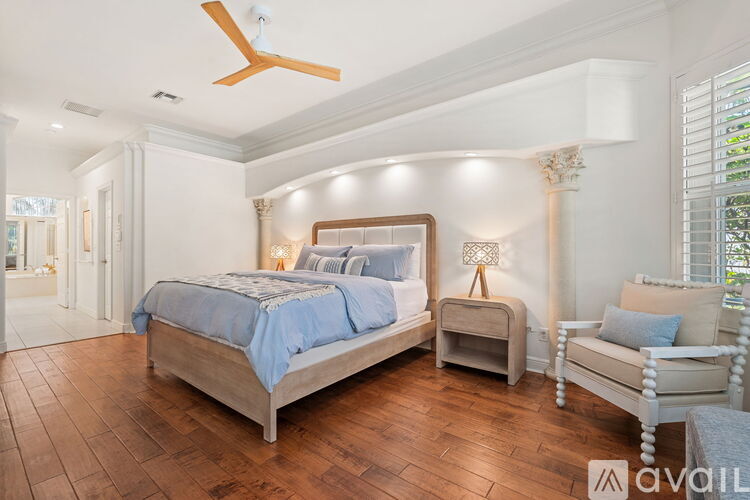 A bedroom with a large bed and a ceiling fan.