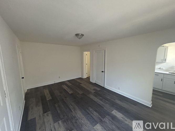 A room with a wooden floor and white walls.