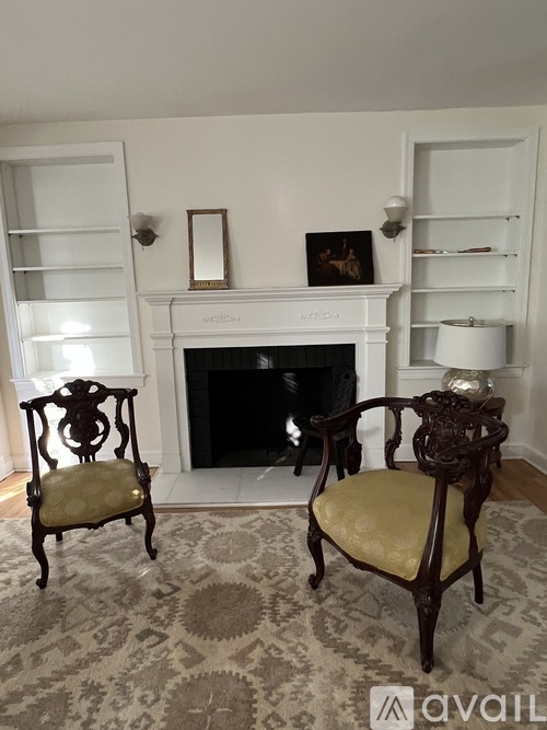 Two chairs are placed in front of a fireplace.