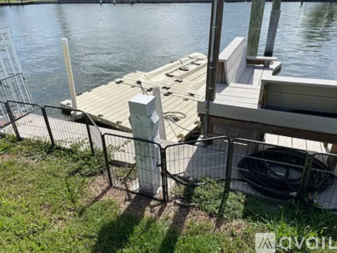 A dock with a white railing and a black grill on it.