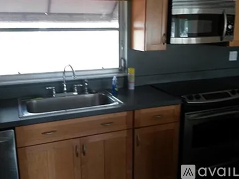 A kitchen with wooden cabinets and a stainless steel sink.