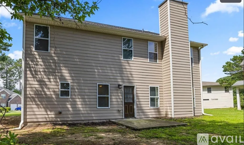 A house with a beige exterior and a chimney is for sale.