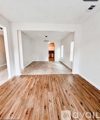 A room with wooden flooring and white walls.