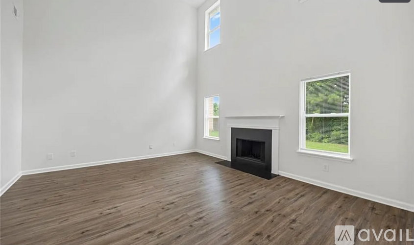 A spacious room with a fireplace and a window.