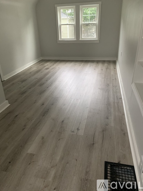 A room with wooden flooring and a window.