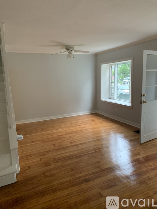 A room with wooden flooring and a ceiling fan.