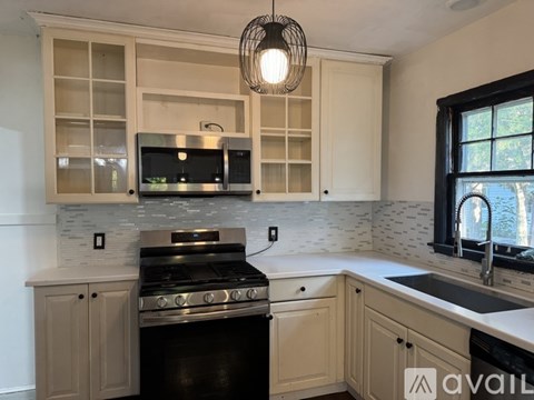 A kitchen with a black stove top oven and a microwave above it.