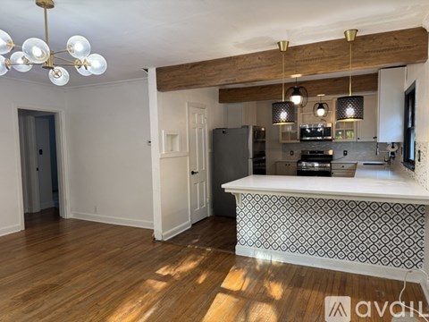 A kitchen with a white island and wooden floors.