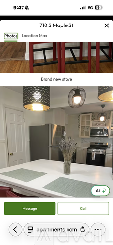 A kitchen with a white countertop and a vase with branches on it.