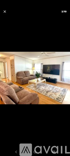 A living room with a large couch and a rug.