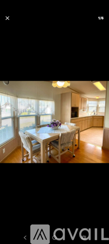 A dining area with a table set for four and chairs around it.