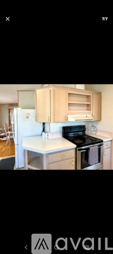 A kitchen with a white refrigerator and a wooden cabinet.