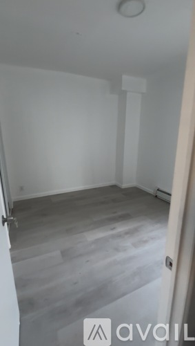 A room with a wooden floor and white walls.
