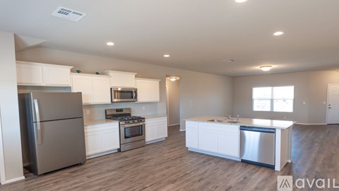 A spacious kitchen with white cabinets and stainless steel appliances.