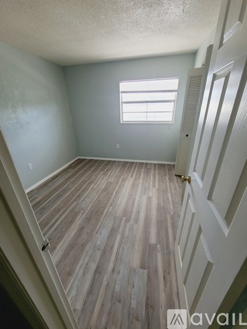 A room with wooden flooring and a window.