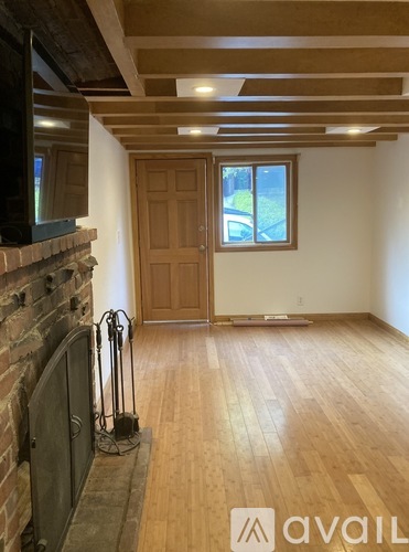 A room with wooden floors and a brick fireplace.