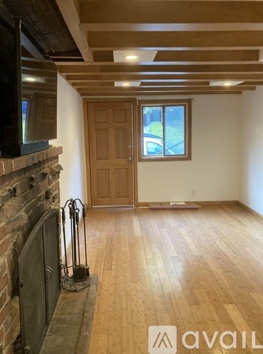 A room with wooden floors and a brick fireplace.