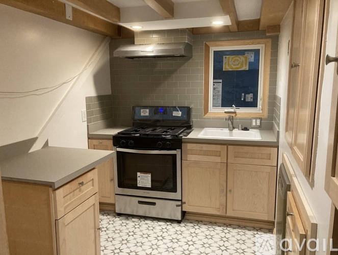 A kitchen with a black stove top oven and a white sink.