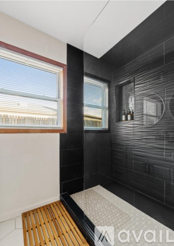 A bathroom with a window and a shower area.