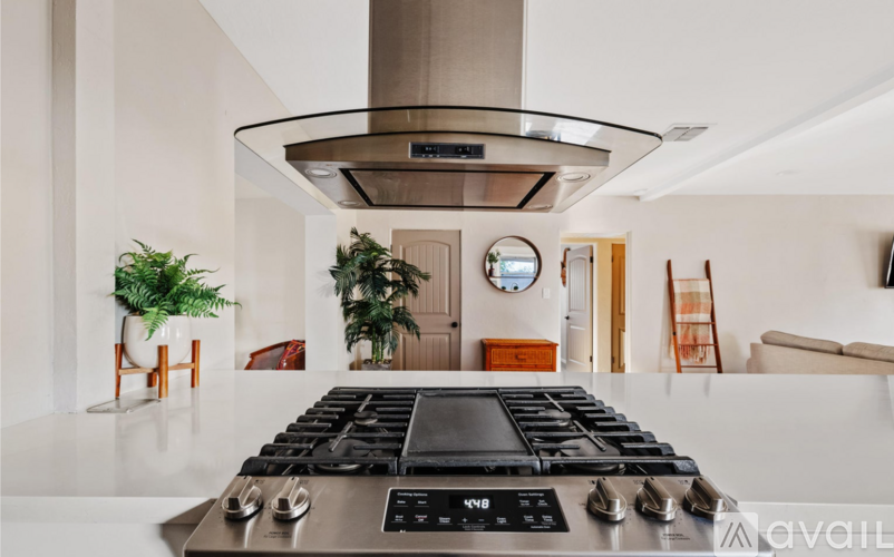 A modern kitchen with a stainless steel stove top and a large island.
