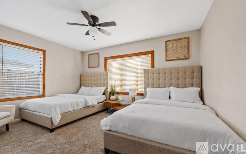 A bedroom with two beds and a ceiling fan.