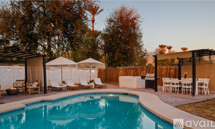 A pool area with lounge chairs and a canopy.