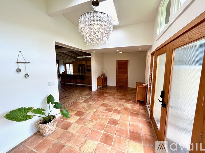 A large open space with a tiled floor and a chandelier hanging from the ceiling.