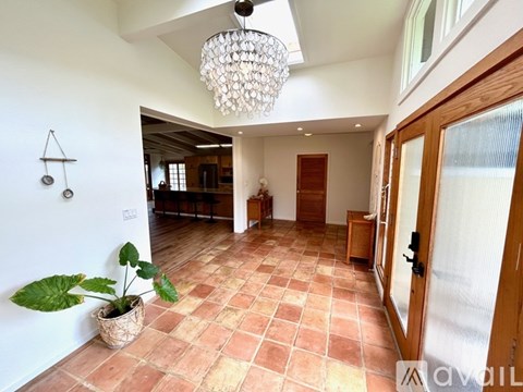 A large open space with a tiled floor and a chandelier hanging from the ceiling.