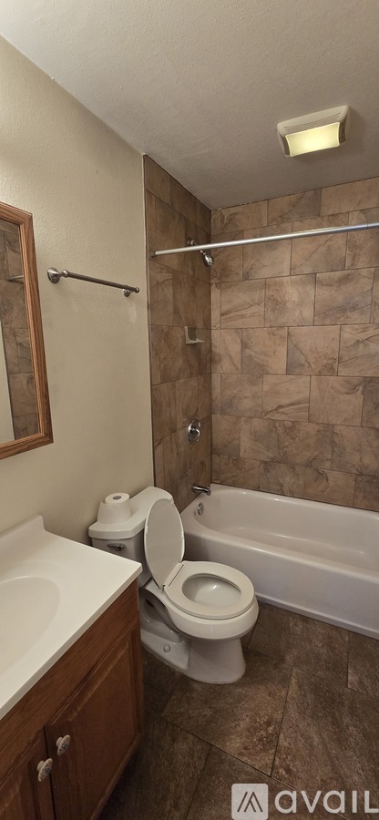 A bathroom with a toilet, sink, and bathtub.