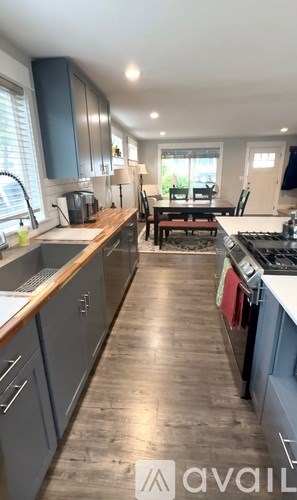 A kitchen with wooden floors and a countertop with a sink.