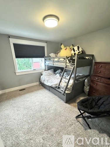 A child's bedroom with a bunk bed and a chair.