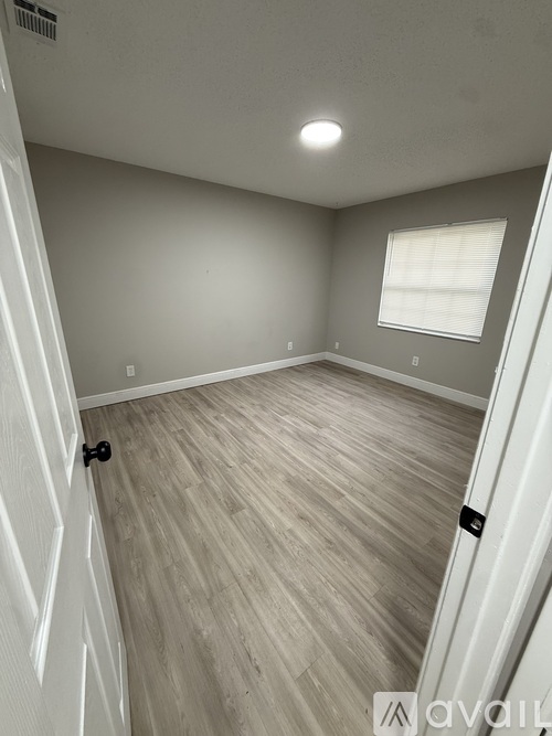 A room with light grey walls and a wooden floor.