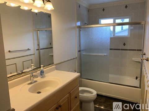 A bathroom with a sink, toilet, and shower.