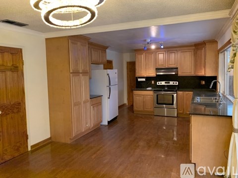 A kitchen with wooden cabinets and a black countertop.