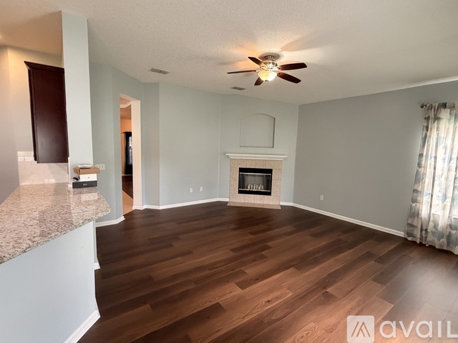A living room with a fireplace and a ceiling fan.