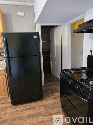 A black fridge and stove in a kitchen.
