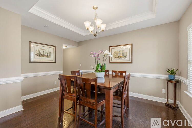 A dining room with a wooden table and chairs.
