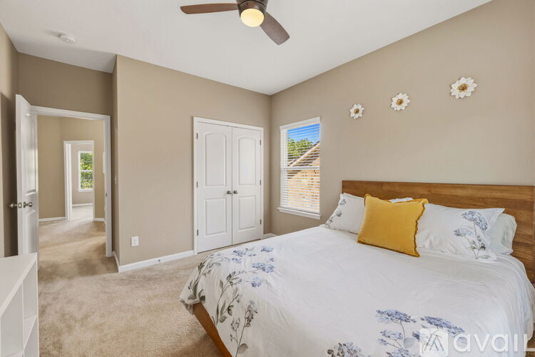 A bedroom with a large bed and a ceiling fan.